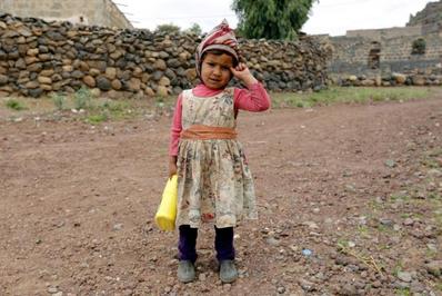 کودک یمنی با روغن مایع توزیعی سازمان ملل به دست در خیابانی در شهر صنعا